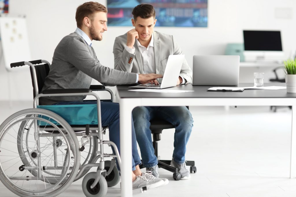 Man in wheelchair working on laptop|College student in wheelchair