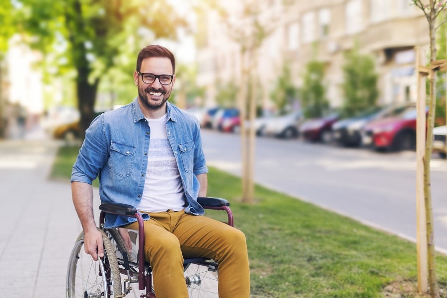 Person in Wheelchair Smiling|Man Speaking with Someone about SSDI