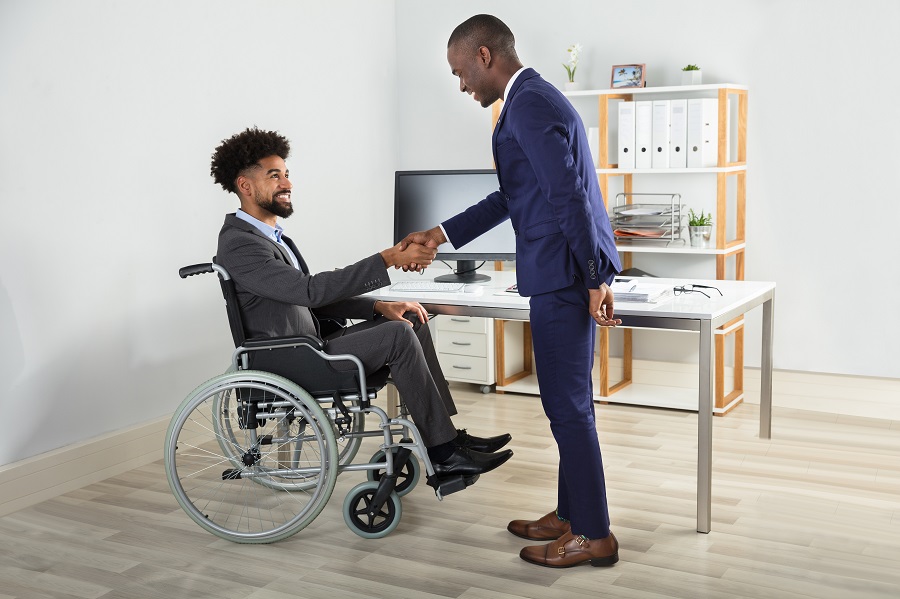 Person in Wheelchair Shaking Hands with Someone|Person Reviewing Forms