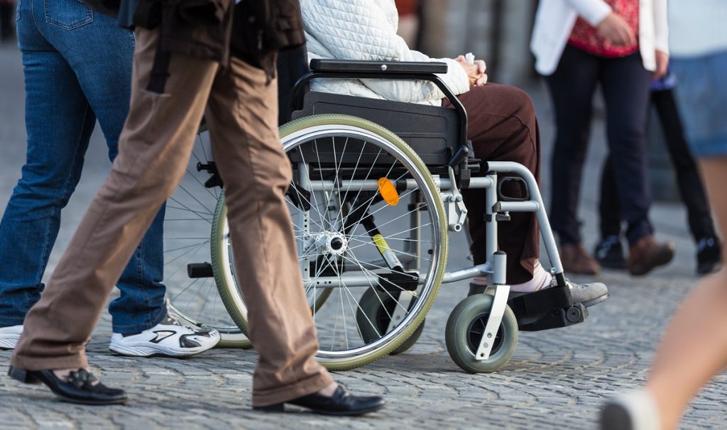 A Disabled Person On Wheelchair and other person walking around|Wheelchair in a Crowd|Worker's Compensation Claim Form