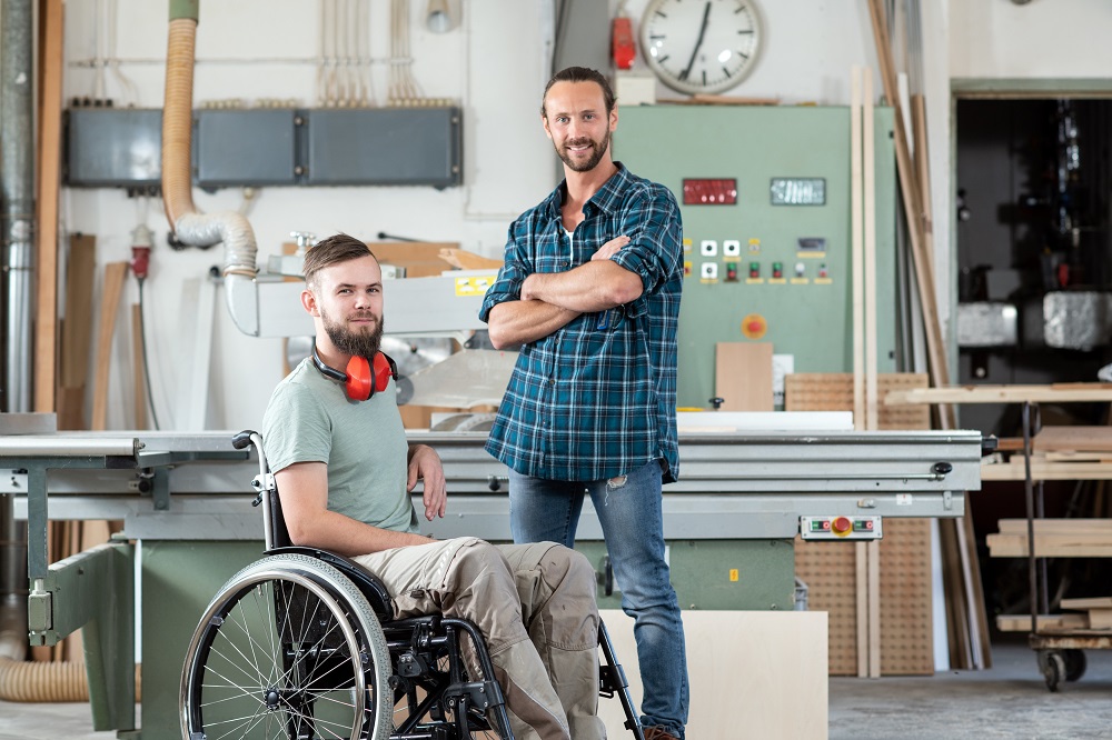 Disabled carpenter and coworker|Disabled businessman with laptop