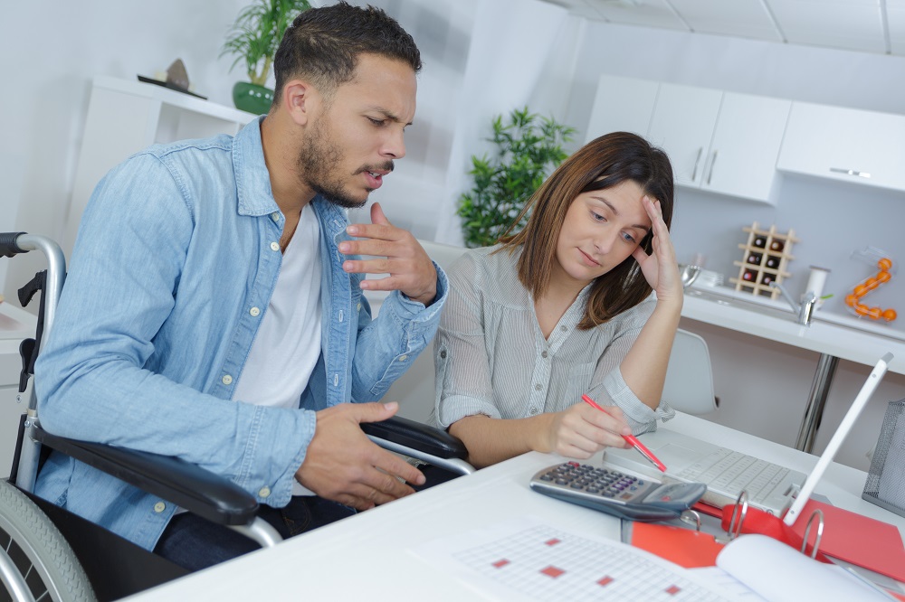 Disabled Worker in Wheelchair Working with Female Coworker